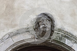 Human face figure as the keystone of an entrance arch to a house.