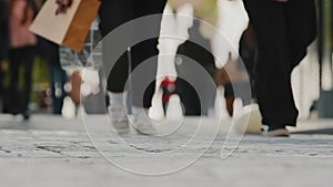 Human feet closeup walking outside on street, crowd many legs moving in downtown, urban busy lifestyle bustle casual