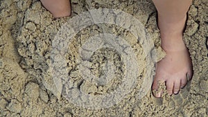 Human feet stand on sand