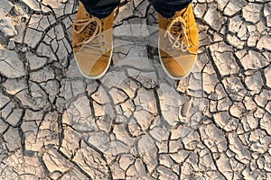 Human feet standing on dried earth