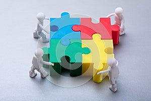 Human Figures Solving Jigsaw Puzzle