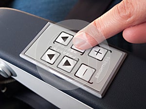 Human finger pressing push buttons on the armrest