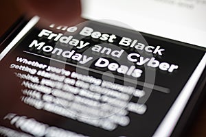 Human finger thumb over Black Friday and Cyber Monday Deals text on shopping app on smartphone screen closeup