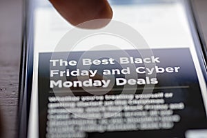 Human finger thumb over Black Friday and Cyber Monday Deals text on shopping app on smartphone screen closeup