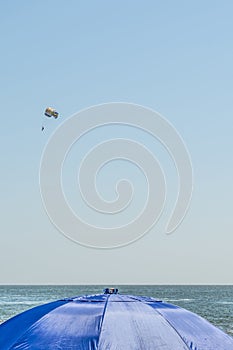 Human is flying on a parachute, clear sunny day with an inimitable sky, entertainment abstract background