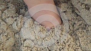 Human foot buried in sand