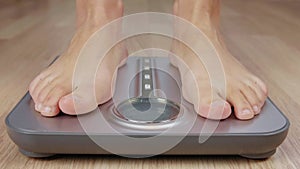 Human foot stepping on weighting scale for body mass control while losing weight