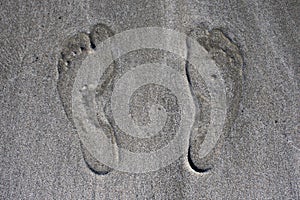 Human footprints on beach sand, close up