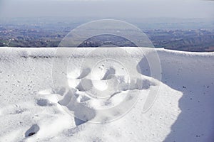 Human footprints in deep snow on sunny day .