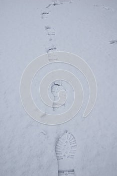 Human footprints on the snow, winter path