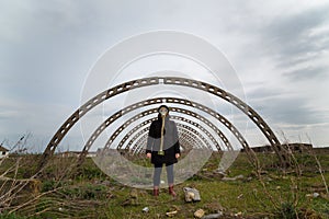 Human in gas mask standing among ruins and dramatic sky background.