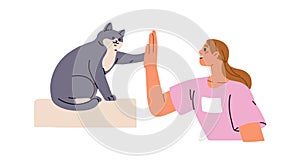 Human giving high five to cute cat. Smart feline animal greeting owner, clapping paw on hand, hi gesture. Pet