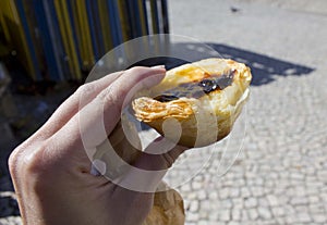 Human han hanging a bite Pastel De Nata