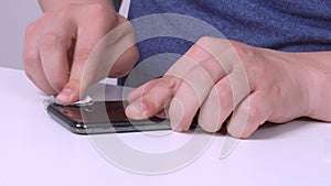 Human hand with accuracy wiping out the black screen of modern mobile phone