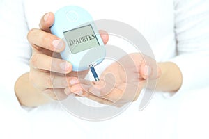 Human hand checking blood sugar with digital tear meter diabetes health check Health and medical concepts