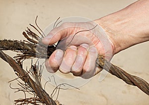 Human hand compresses old steel cable