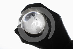 Human hand with cotton gloves gripping glass globe