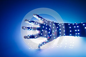 Human hand covered with blue led lights, illuminated background