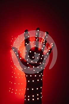 Human hand covered with red led lights, illuminated background