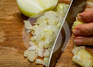 Human hand dicing onion with a sharp knife