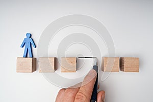 Human Hand Filling Gap Between Wooden Blocks photo