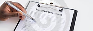 Human Hand Filling Sexual Harassment Complaint Form With Pen