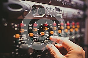 Human hand fine tuning levels on professional audio equipment