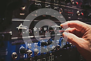 Human hand fine tuning levels on professional audio equipment