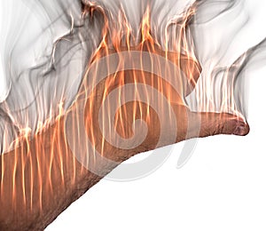 A human hand on fire burning with orange flames and some smoke in front of a bright background