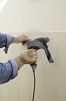 Human hand holding drill machine