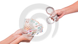 Human hand holding euro money and handcuffs. Fan of euro banknotes.