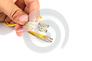 Human hand holding fiber optic patch cord