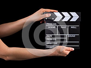 Human hand holding film clapper board isolated on black background