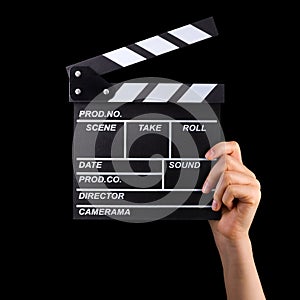 Human hand holding film clapper board isolated on black background