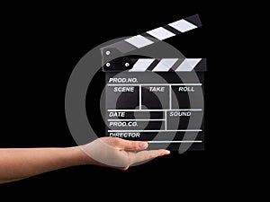 Human hand holding film clapper board isolated on black background