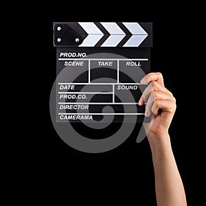 Human hand holding film clapper board isolated on black background