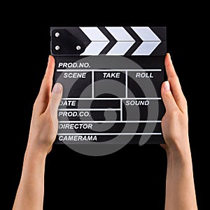 Human hand holding film clapper board isolated on black background