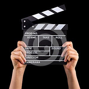 Human hand holding film clapper board isolated on black background