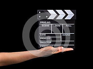 Human hand holding film clapper board isolated on black background