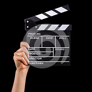 Human hand holding film clapper board isolated on black background