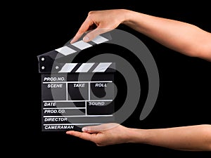 Human hand holding film clapper board isolated on black background with clipping path