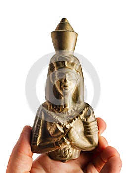 Human hand holding golden pharaoh statuette