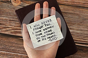 Human hand holding handwritten Bible quote about God Jesus Christ`s love