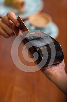 Human hand holding plastic card in payment machine