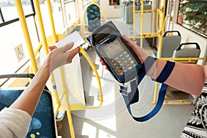 Human hand holding plastic cards. Passenger pays for fare in public transport. Payment terminal, credit card reader, sales concept