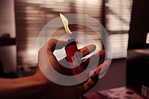 A human hand holding a red lighter