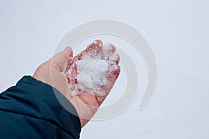 Human hand holding white snow