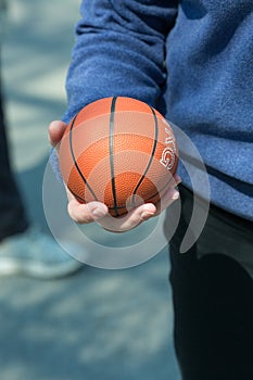 The human hand holds the ball.