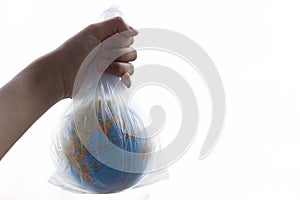 The human hand holds the planet earth in a plastic bag.