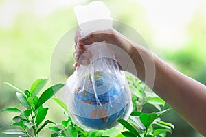 The human hand holds the planet earth in a plastic bag.